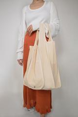 a woman using the organic cotton tote bag from zero waste shopping essentials starter gift box