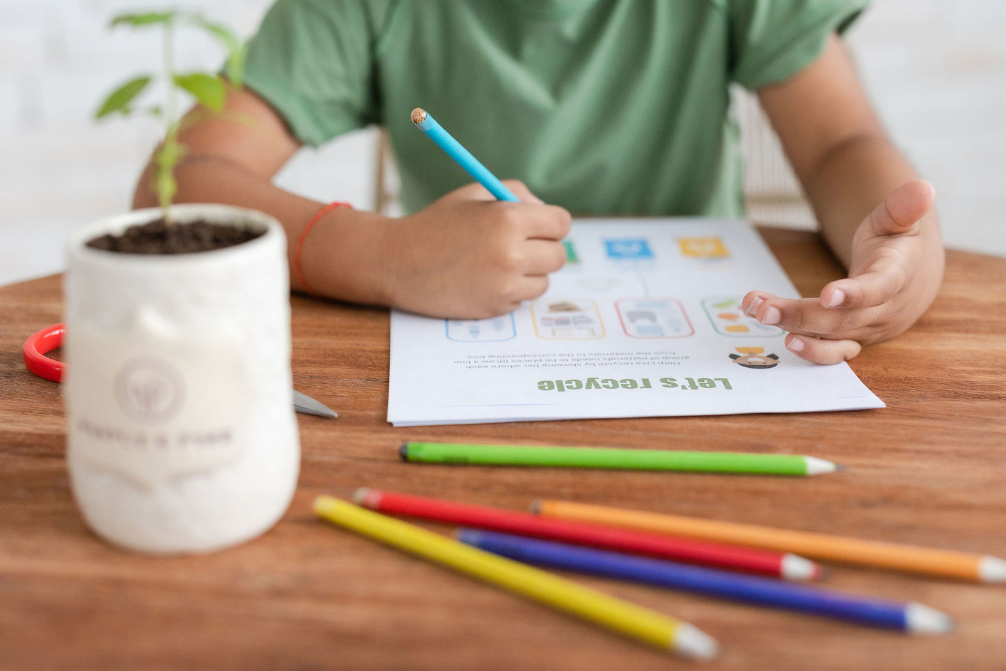 a boy using ecogrow seed pencils of purple & pure, plantable gifts