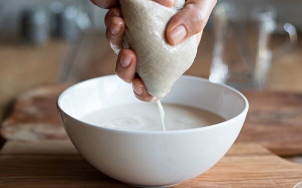 squeezing almond milk using the organic nut milk bag from purple & pure